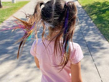 reviewers childs hair with rainbow tinsel in it