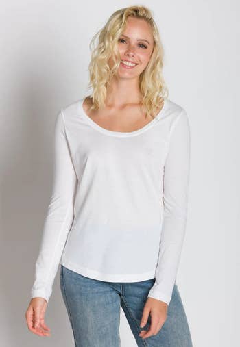 a model wearing the long sleeve shirt in white 