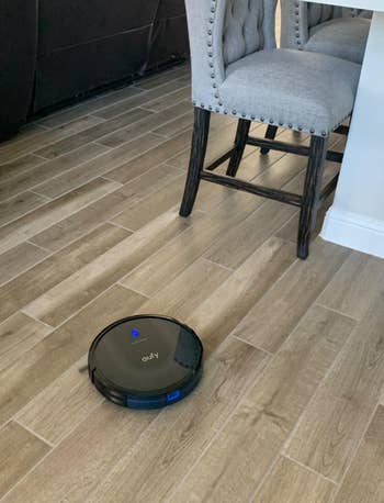 reviewer's robot vacuum running on their hardwood floor