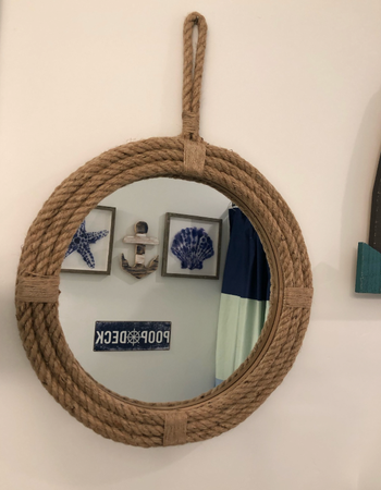 closeup of reviewer's round rope mirror hanging on a wall 