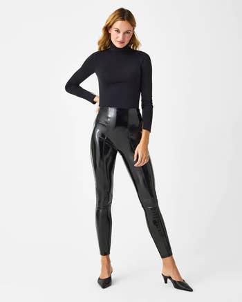 Model in shiny black faux leather leggings 