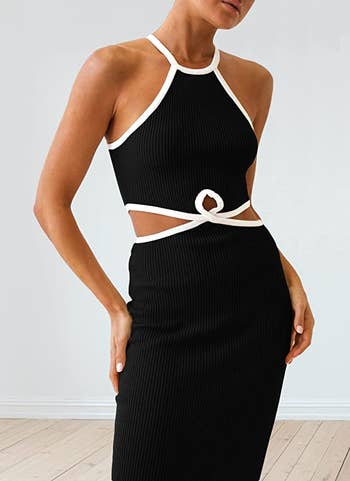 model wearing black dress with cutouts at the waist