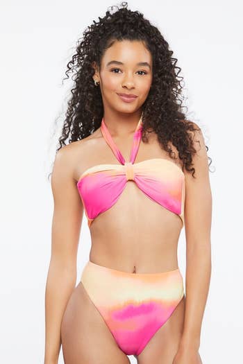 model in high-waisted orange and pink halter suit