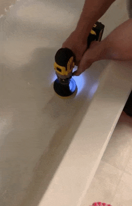 a gif of someone using the drill brush to clean their bathtub
