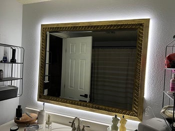Reviewer with the light strips behind the mirror to create a backlight effect
