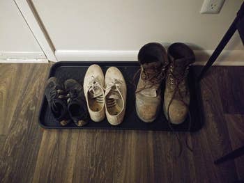 reviewer image of the boot tray with three different pairs of shoes in it