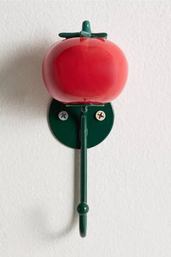 Tomato-shaped hook mounted on a wall, suitable for home decor and organization