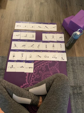 a reviewer using the cards to do yoga poses