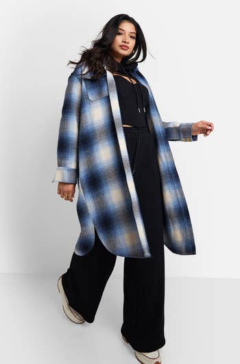 model in open blue plaid midi shacket with black pants and top