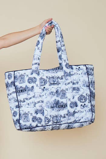 hand holding the blue and white quilted bag