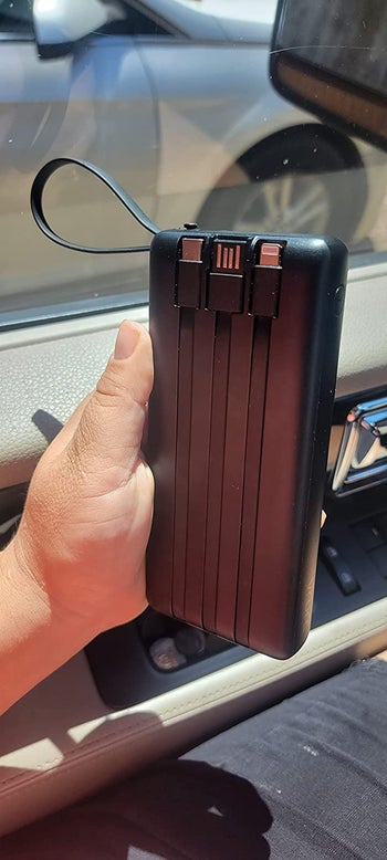 reviewer holding the black charger with cords built in