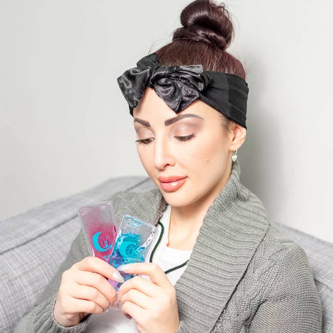 model wearing the black headband and holding two mini ice packs