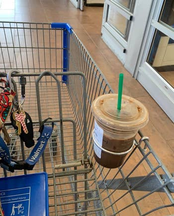 a reviewer photo of a Starbucks iced coffee in the cup holder that's mounted on a Walmart shopping cart 