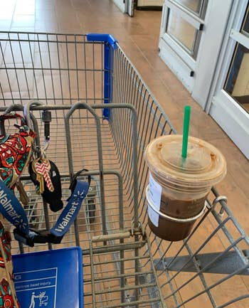 a reviewer photo of a Starbucks iced coffee in the cup holder that's mounted on a Walmart shopping cart 
