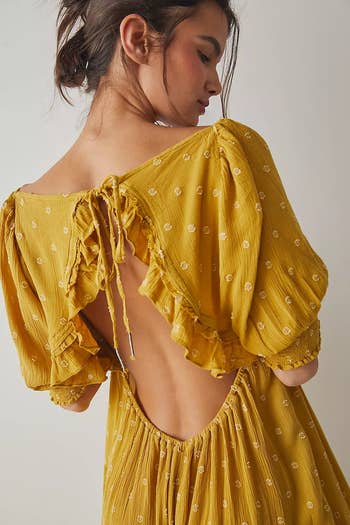 back of model wearing the yellow jumpsuit to show the tie detail