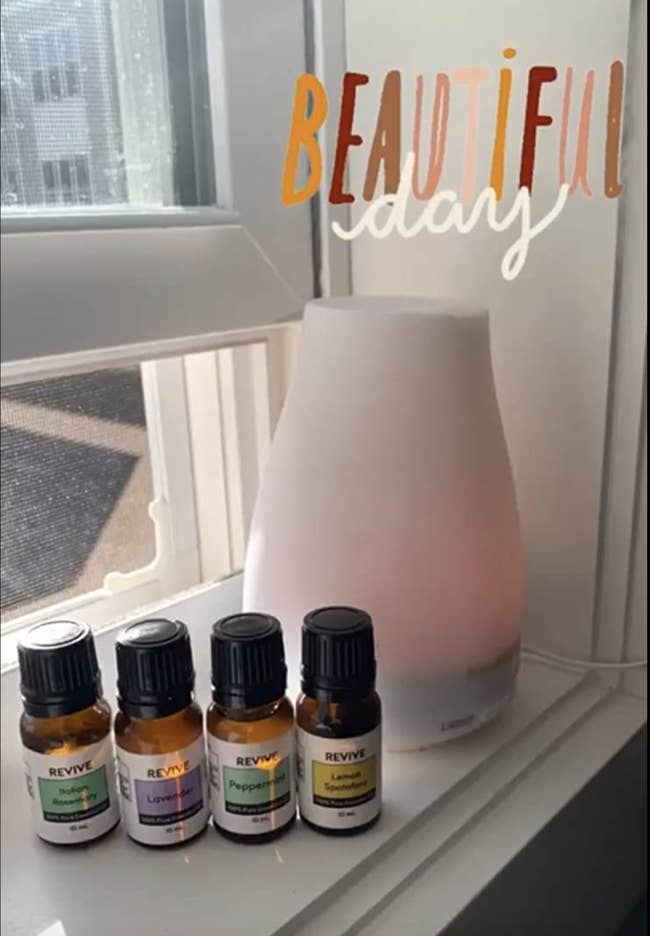 A white diffuser set on a window ledge next to scents 