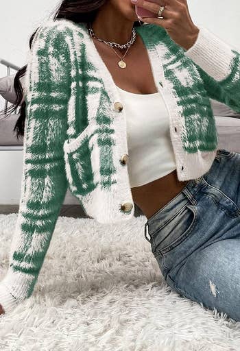 a model in the green and white plaid sweater with tortoiseshell buttons