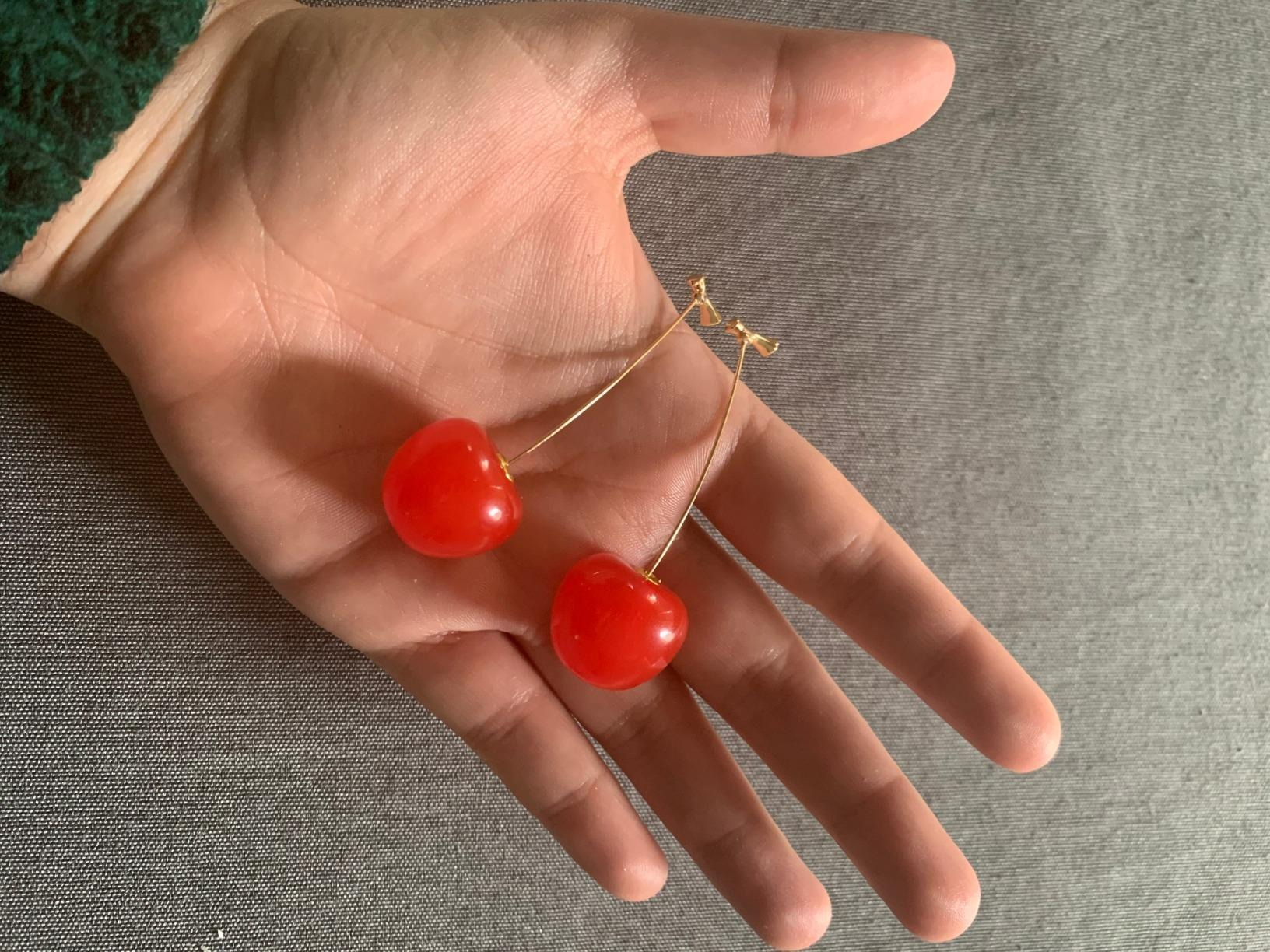 the reviewer holding the earrings in their hand