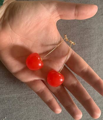 the reviewer holding the earrings in their hand