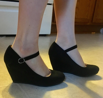 Reviewer wearing black wedge shoes
