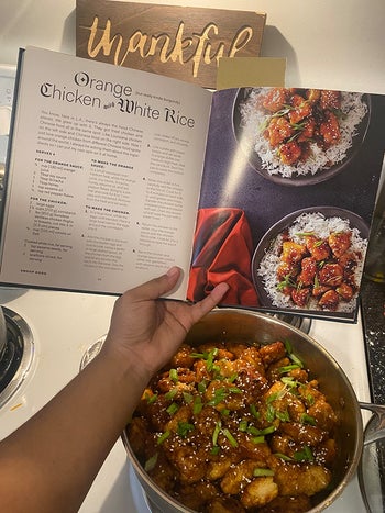 reviewer making a meal from the book with book open to the recipe page