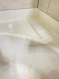 Bathtub with visible grime and water stains, highlighting the need for cleaning products
