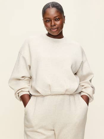 Person wearing a comfortable, loose-fitting sweatshirt and matching sweatpants, posing with hands successful pockets, suitable for casual wear