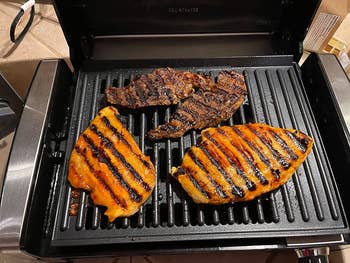 A reviewer's grill with chicken on it that has very nice grill marks