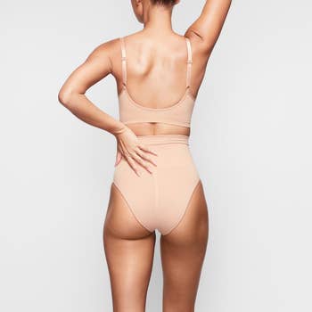 model showing back view of tan colored sculpting briefs