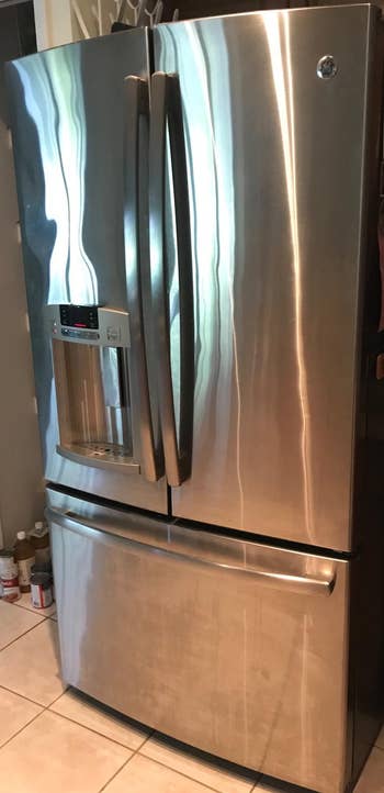 Reviewer showing dirty stainless steel refrigerator before
