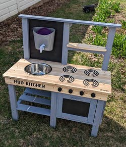 A child's wooden play kitchen with a 
