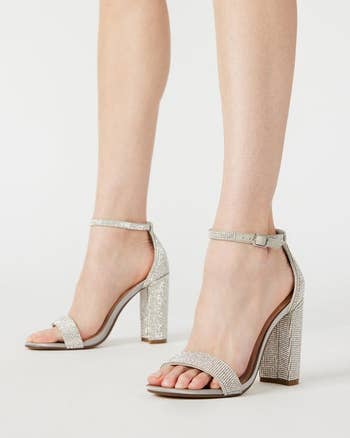 model in silver rhinestone ankle strap heels