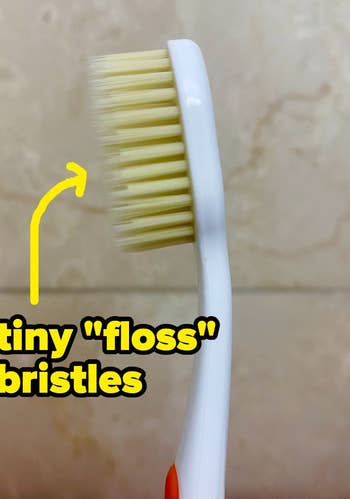BuzzFeeder's photo of the toothbrush, with an arrow pointing towards the bristles with text: tiny 