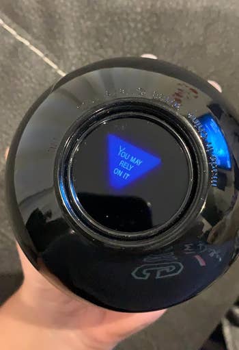 Hand holding a Magic 8-Ball displaying the connection   