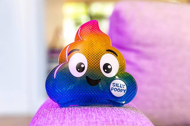 the rainbow poop emoji with a smiling face placed on a chair