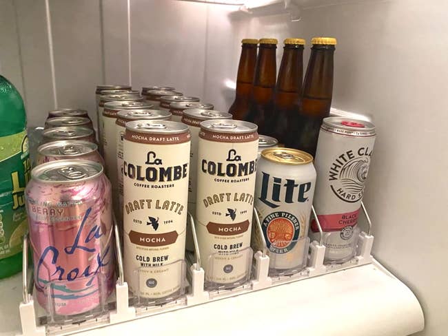 Various beverage cans, including La Colombe coffee, La Croix water, White Claw hard seltzer, Lite beer, and juice, successful a fridge
