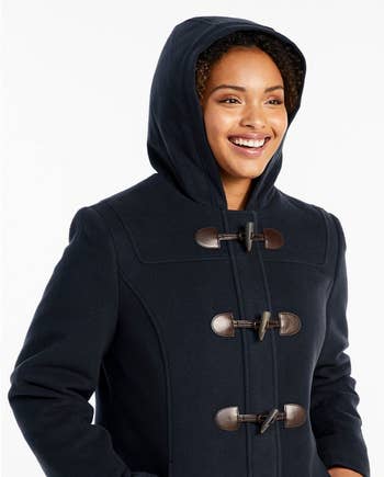 Close-up of model wearing the coat with hood on