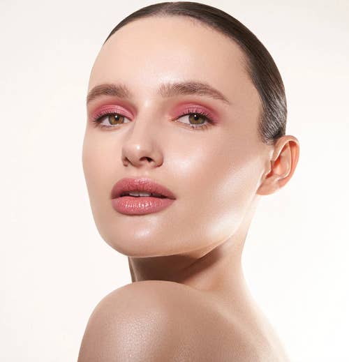 a model wearing light pink on their eyes and lips