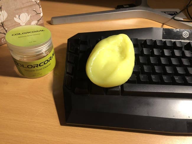 yellow slime-like putty with debris cleaned out from black computer keyboard