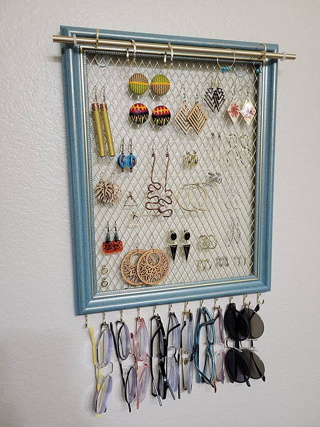 Reviewer image of blue and gold earring organizer with earrings and sunglasses  hanging from it