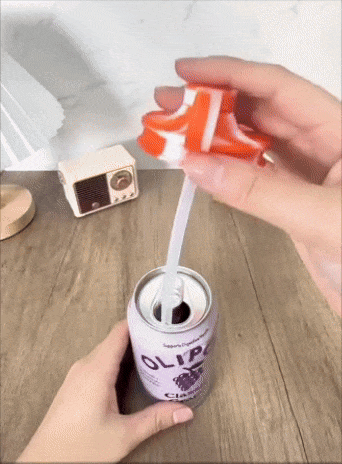 Hand placing a headdress  with a built-in straw onto a soda can, creating a spill-proof drinking solution