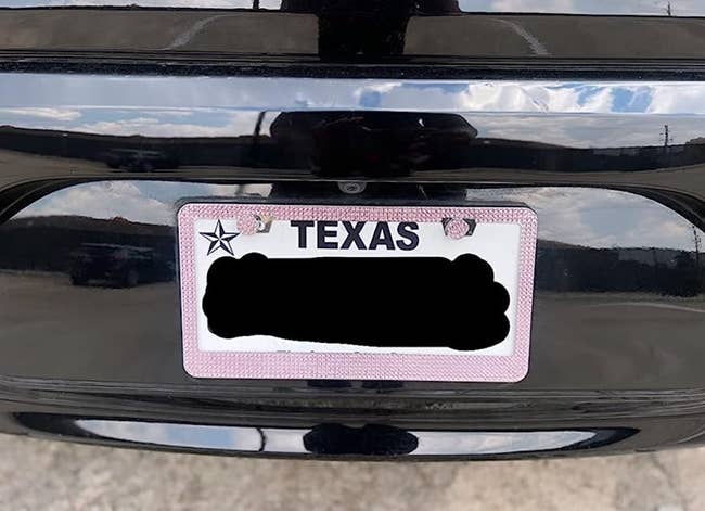 pink bedazzled license plate frame on a car 