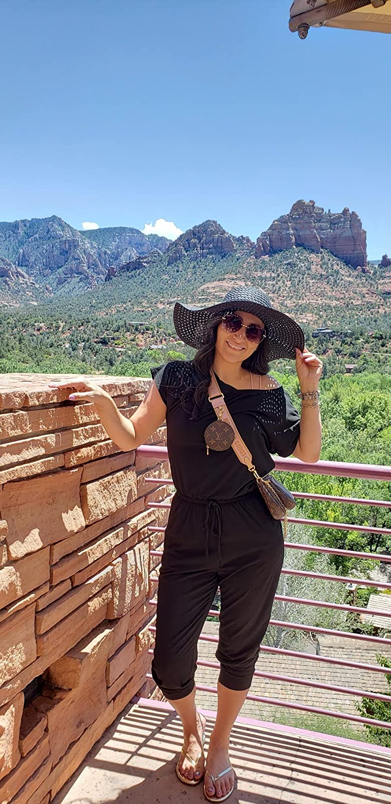 reviewer wearing the black jumpsuit while standing in front of mountain scenery