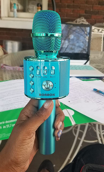 a reviewer holding the microphone in blue