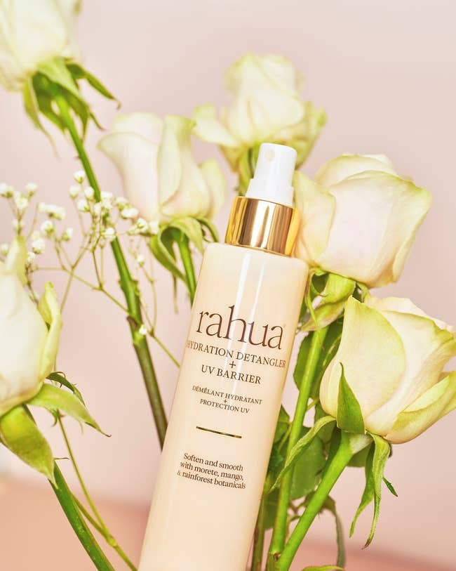 Rahua Hydration Detangler UV Barrier spray vessel  surrounded by achromatic  roses