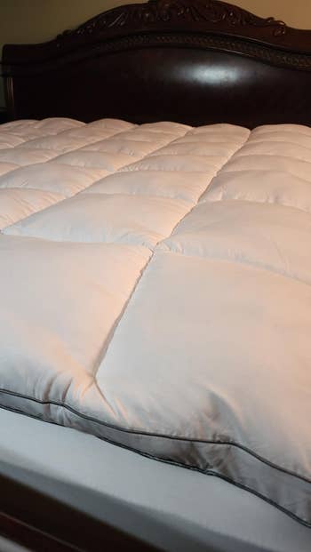 Puffed mattress topper connected a bed, showcasing quilted plan for added comfortableness and support