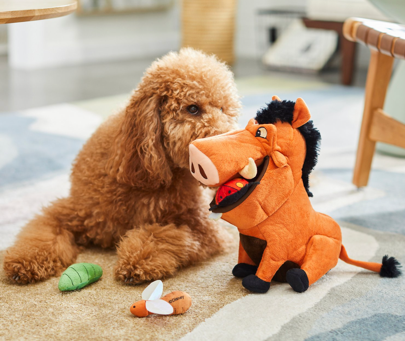 a dog playing with a plush pumbaa that has various little bug toys to find