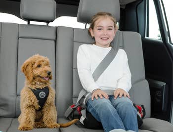 child model sitting on the booster seat in a car