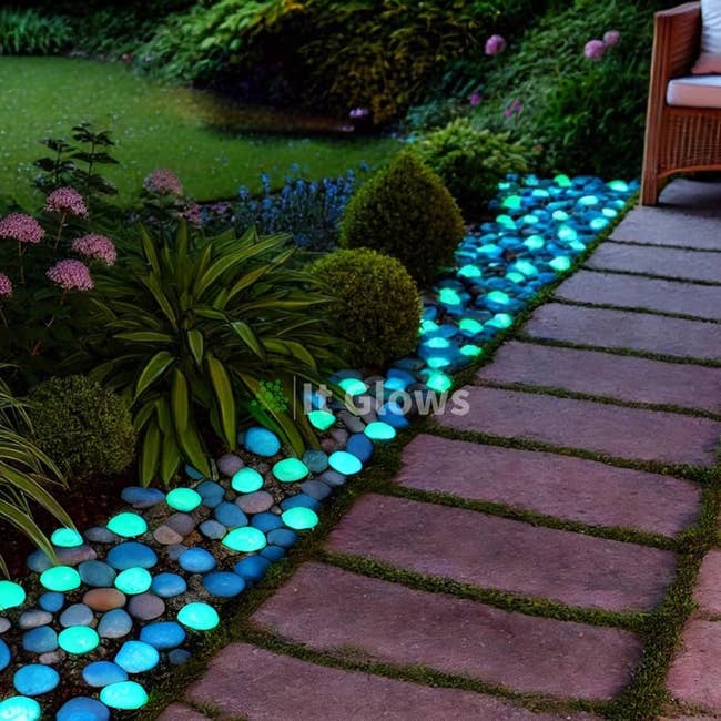 Garden way  lined with glowing pebbles, creating a vibrant, illuminated borderline  alongside plants and a seating area