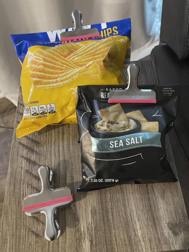 Bags of murphy  chips are sealed with metallic  clips connected  a woody  table